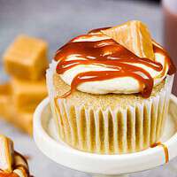 焦糖纸杯蛋糕的图像，里面装有嚼糖焦糖，上面放着焦糖毛毛雨