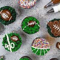 足球纸杯蛋糕的图像，用黄油奶油装饰为超级碗