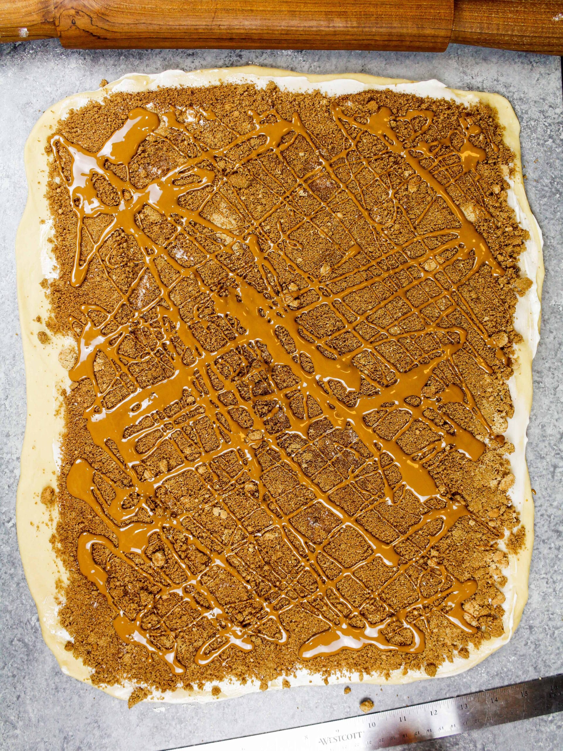 形象biscoff肉桂卷的面团加上肉桂糖,黄油,融化biscoff饼干黄油