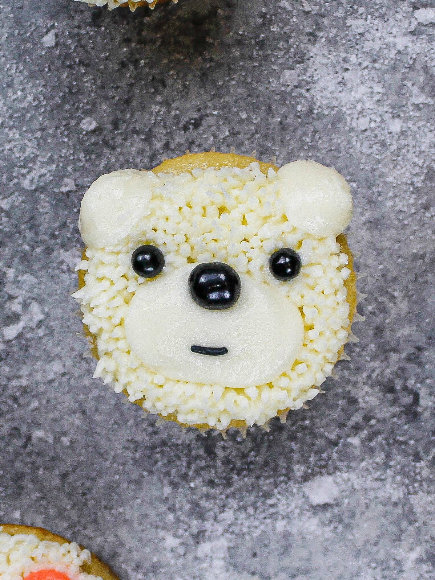 用黄油蛋糕和黑色洒水的北极熊纸杯蛋糕的图像