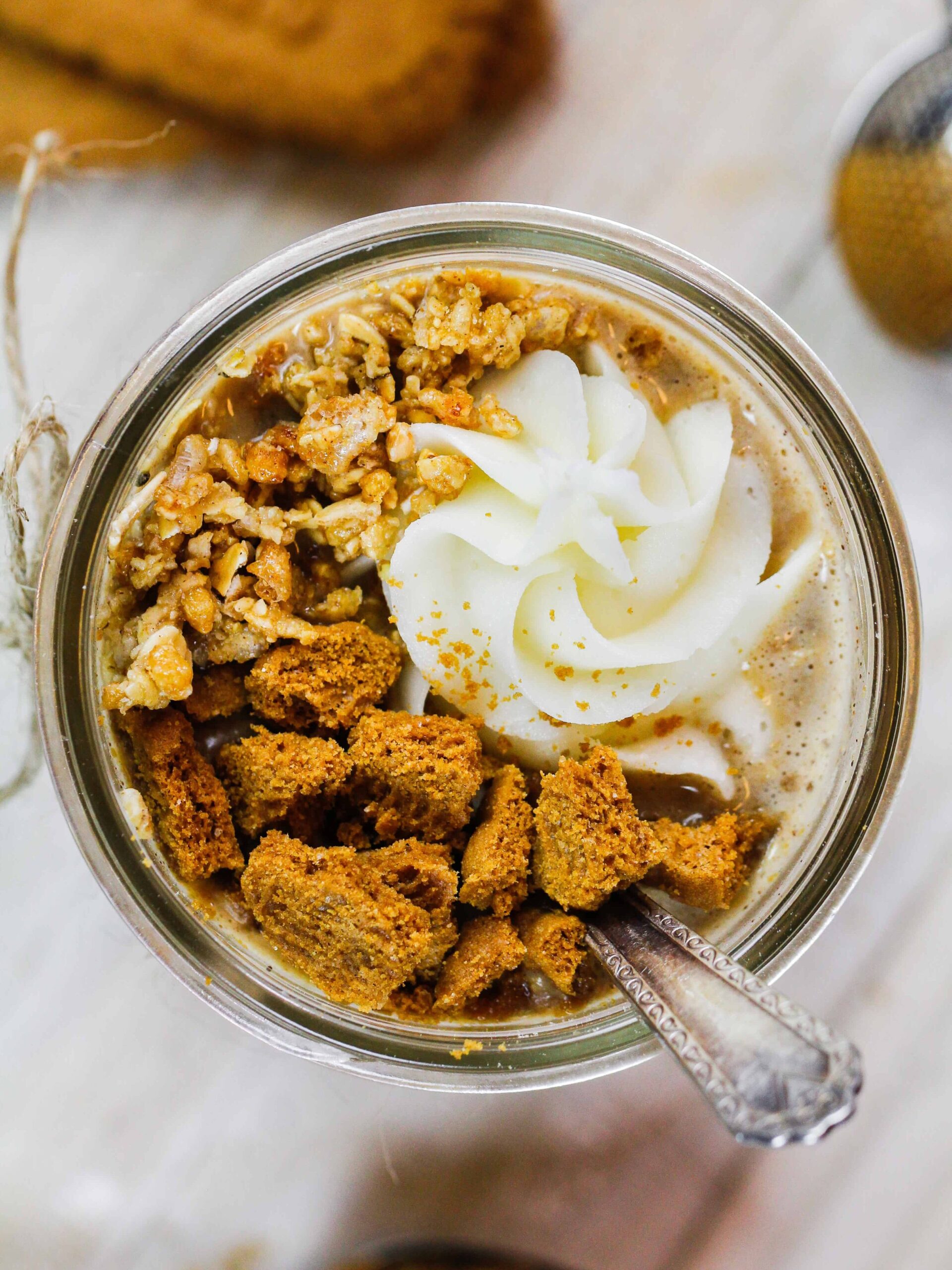 mason jar开销的形象一夜之间充满黄油饼干燕麦加上鲜奶油,切碎biscoff饼干和一些麦片