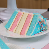 image of a slice of a trans flag cake that's been made with pink, blue and white cake layers