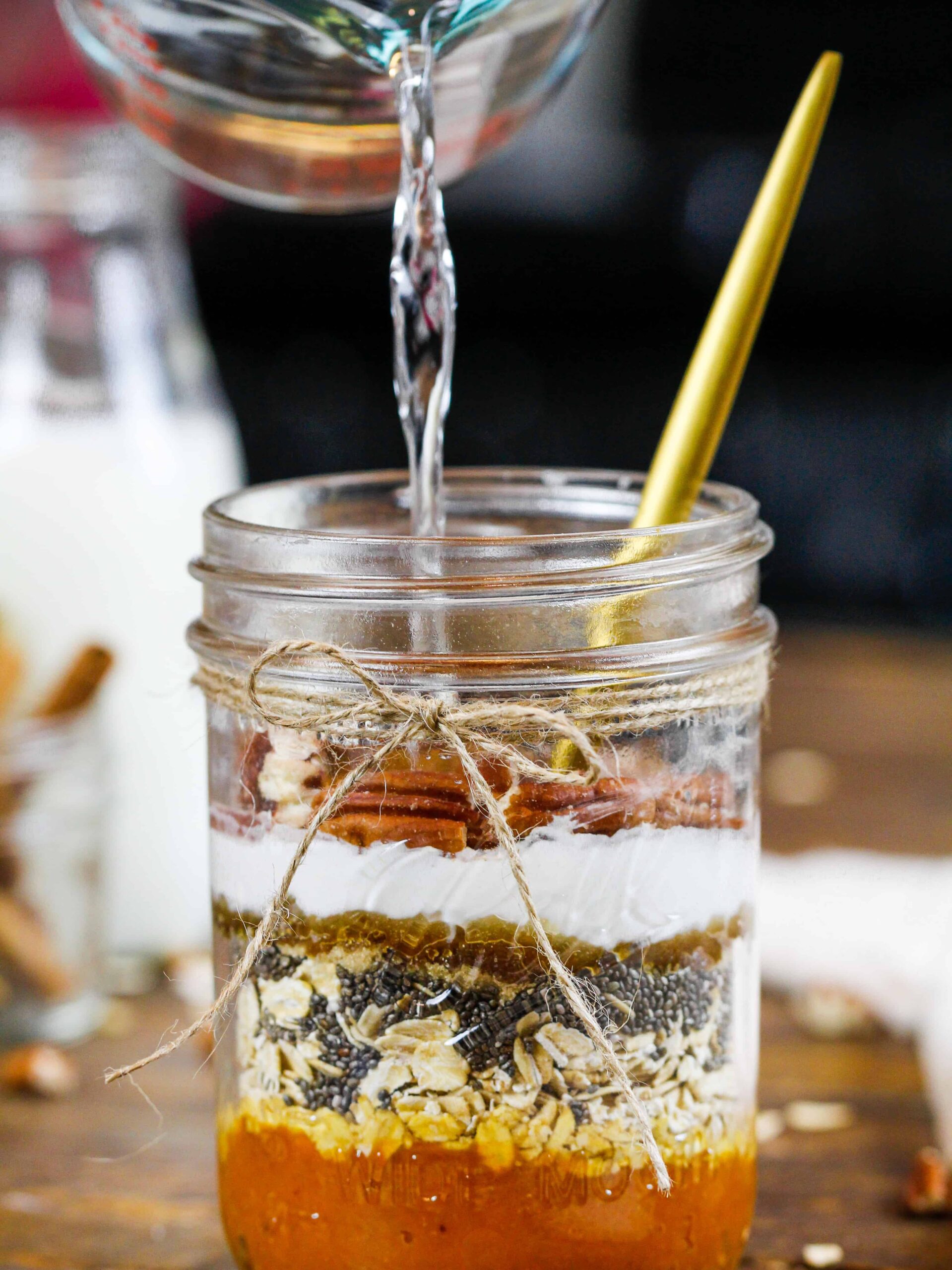 梅森罐子中的南瓜香料过夜燕麦成分的图像充满了水。