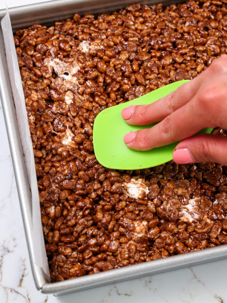 将巧克力大米krispies的图像压入锅中