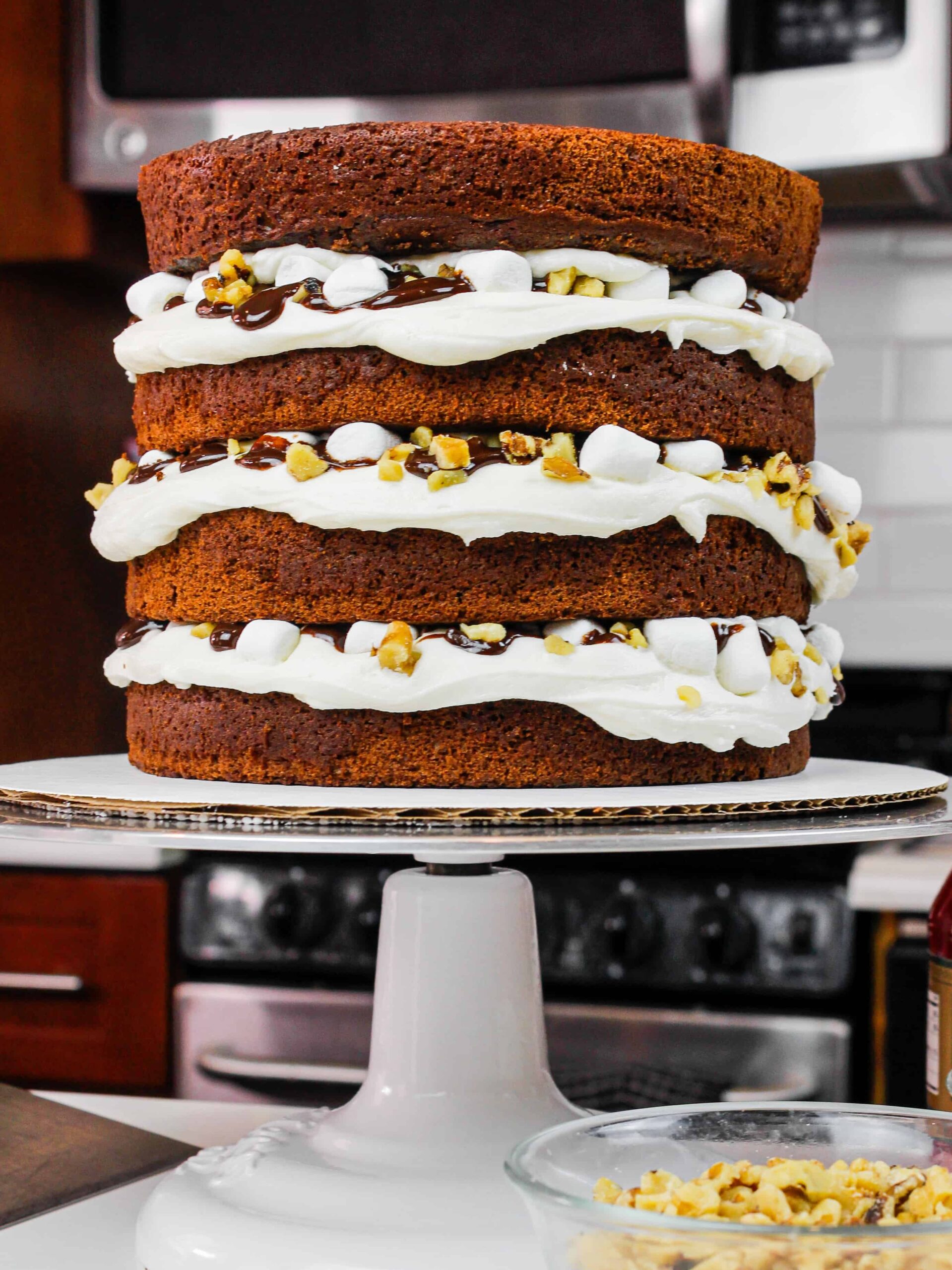 堆叠的形象充满了棉花糖奶油乳酪,巧克力蛋糕层巧克力巧克力酱,迷你棉花糖,和核桃碎坎坷蛋糕