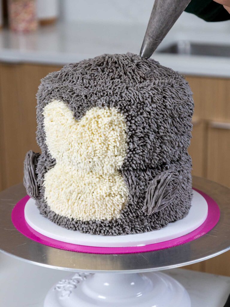 图像的灰色奶油乳酪被输送到一个可爱的小婴儿企鹅蛋糕